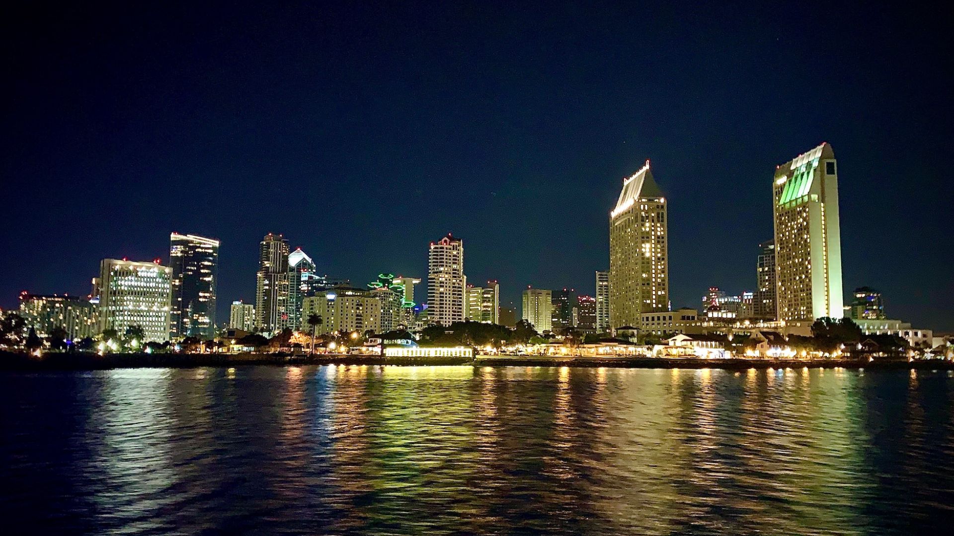 San Diego, California skyline with evening lights reflected in the water.