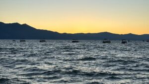Lake Tahoe sunset with boats out on the lake and mountains in the background
